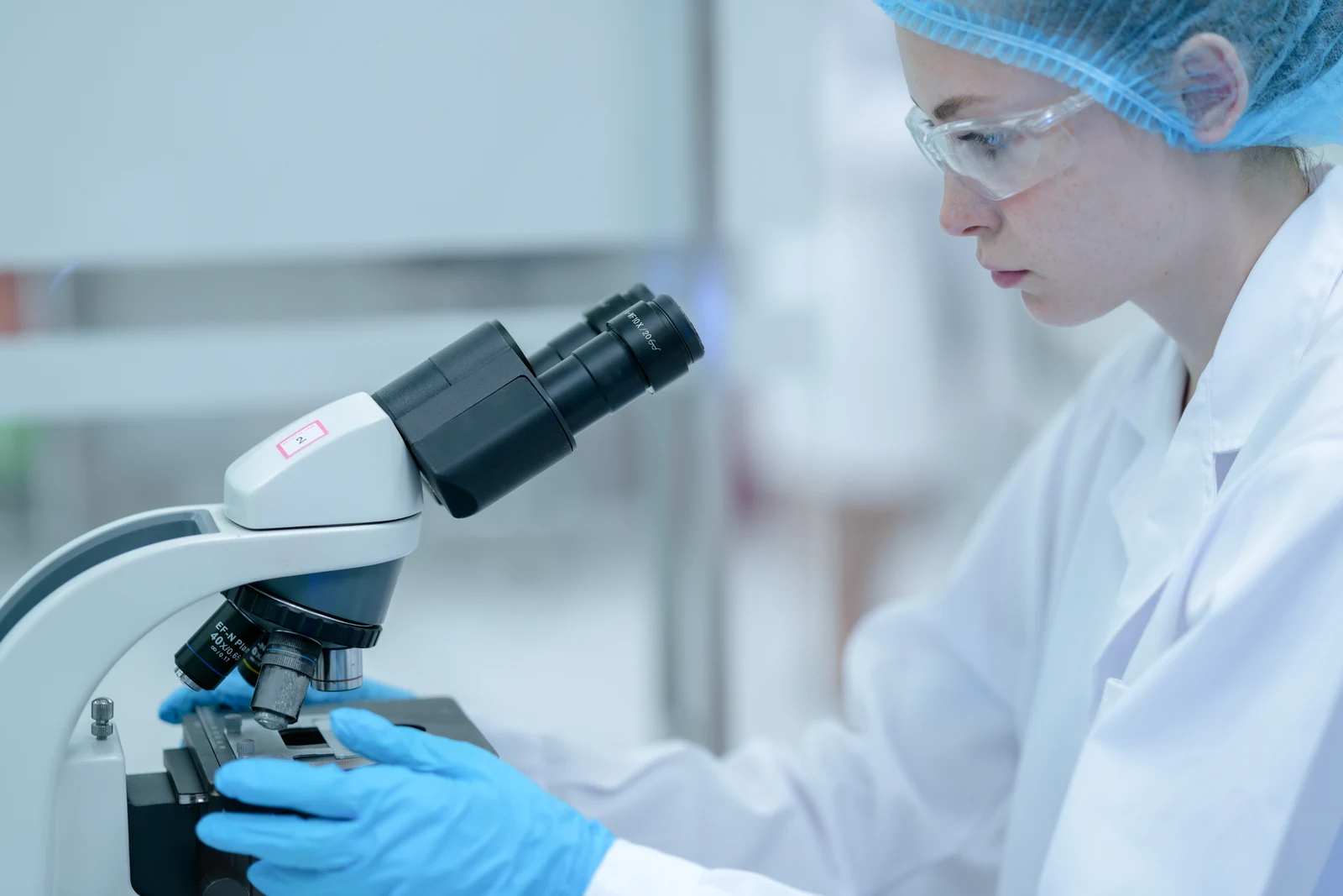 Ricercatrice al microscopio in un laboratorio